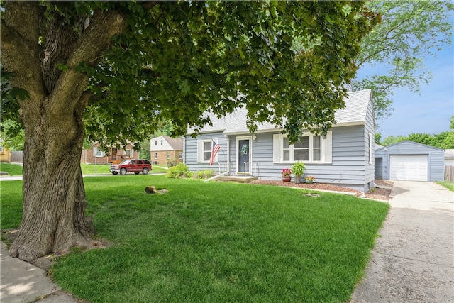 view of front facade featuring a garage, a front yard, and an outbuilding