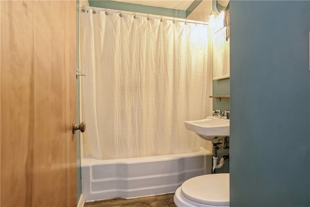 bathroom with shower / tub combo with curtain, hardwood / wood-style flooring, and toilet