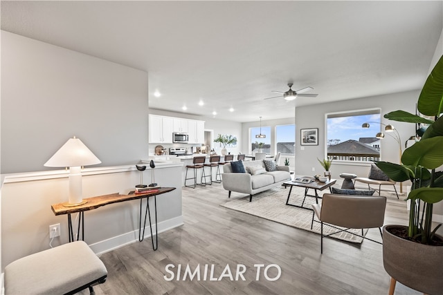 living room featuring recessed lighting, light wood-style floors, and ceiling fan