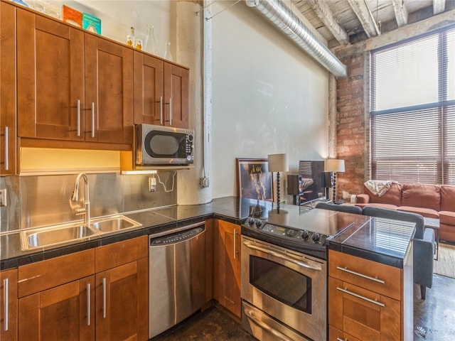 kitchen with kitchen peninsula, stainless steel appliances, tasteful backsplash, beamed ceiling, and sink