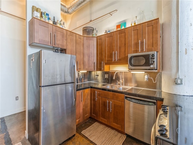 kitchen with appliances with stainless steel finishes, sink, tasteful backsplash, and tile countertops