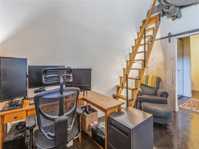 office with a barn door and concrete flooring