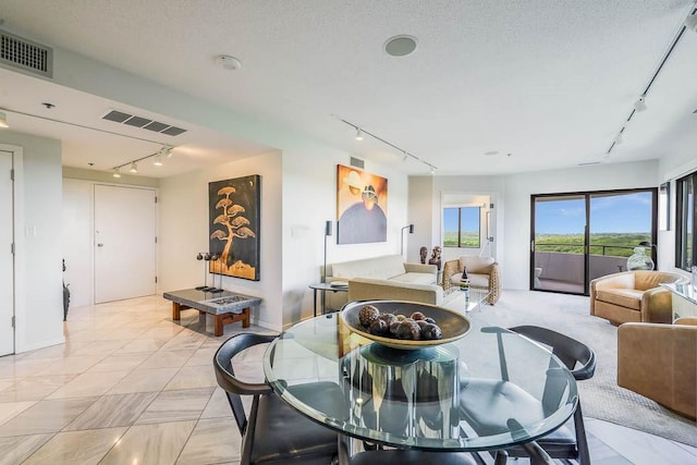 tiled dining room featuring a textured ceiling