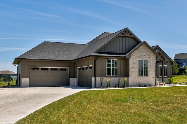 view of front of property with board and batten siding, a front lawn, driveway, and an attached garage