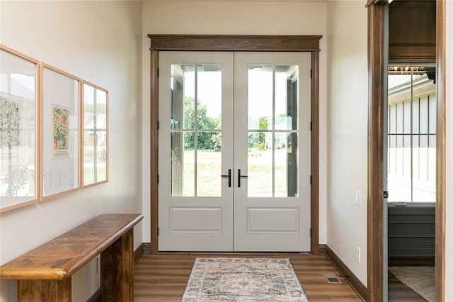 doorway to outside featuring visible vents, baseboards, dark wood finished floors, and french doors