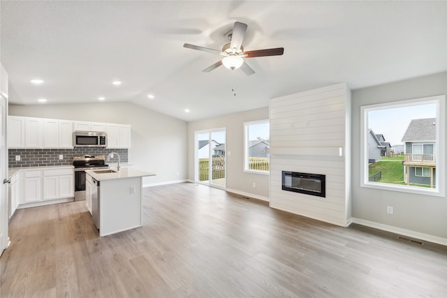 kitchen featuring a kitchen island with sink, white cabinets, stainless steel appliances, and light hardwood / wood-style floors