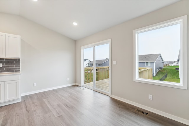 interior space featuring light hardwood / wood-style floors and vaulted ceiling