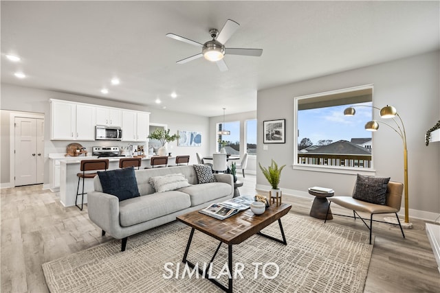 living room featuring ceiling fan and light wood-type flooring