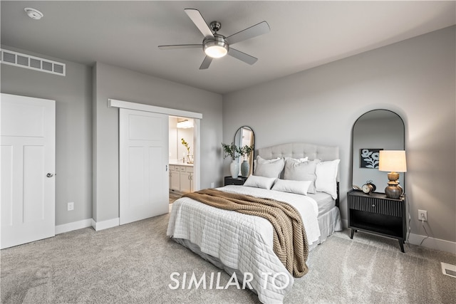 carpeted bedroom featuring ensuite bath and ceiling fan