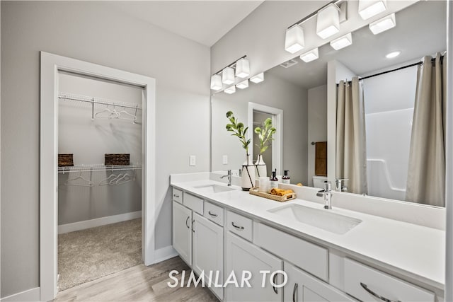 bathroom with a shower with curtain, vanity, and wood-type flooring