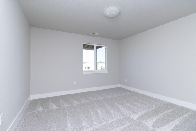 unfurnished room featuring carpet floors, baseboards, and visible vents