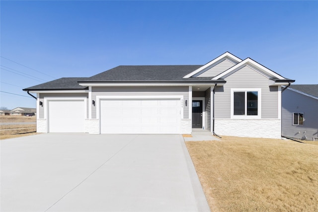 ranch-style house with a garage, a shingled roof, driveway, stone siding, and a front lawn