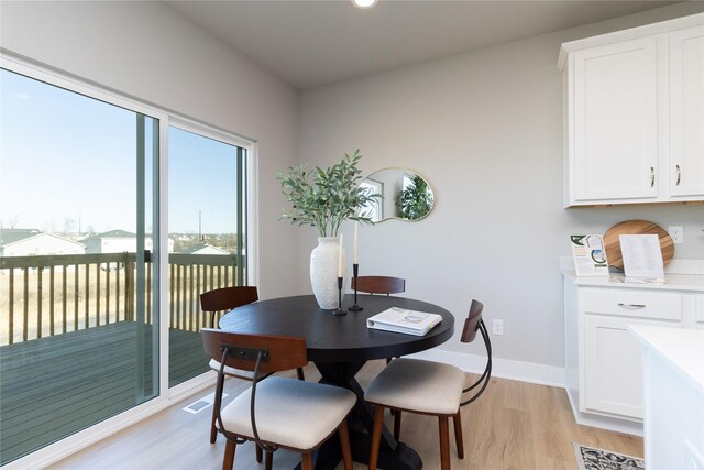 dining space featuring baseboards, visible vents, and light wood-style floors