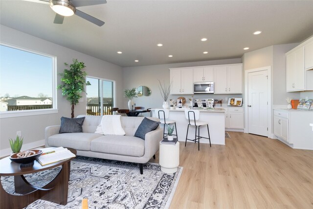 living room with a ceiling fan, recessed lighting, and light wood finished floors