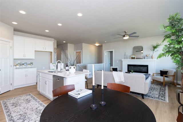 dining area featuring recessed lighting, a glass covered fireplace, and light wood-style floors