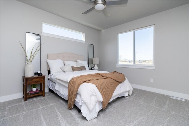 carpeted bedroom with visible vents, multiple windows, and baseboards