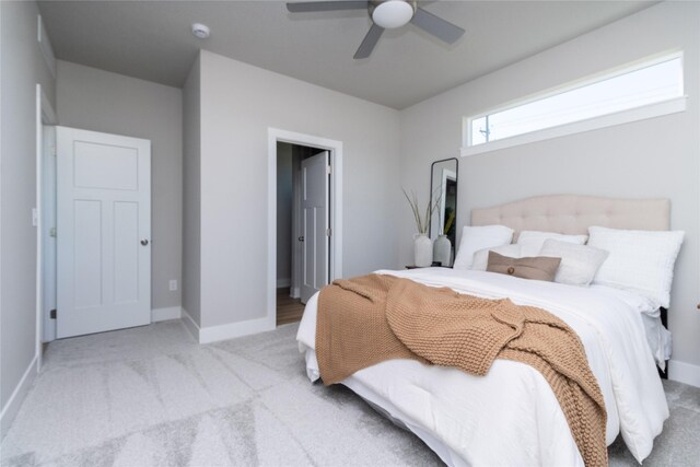 bedroom with light carpet, ceiling fan, and baseboards