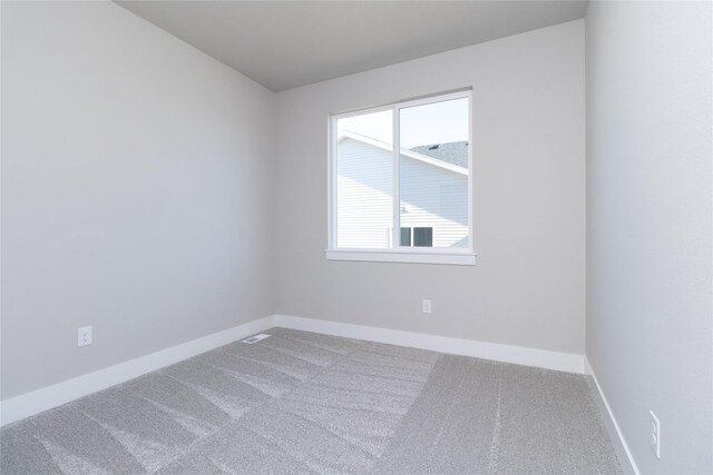 carpeted spare room featuring baseboards