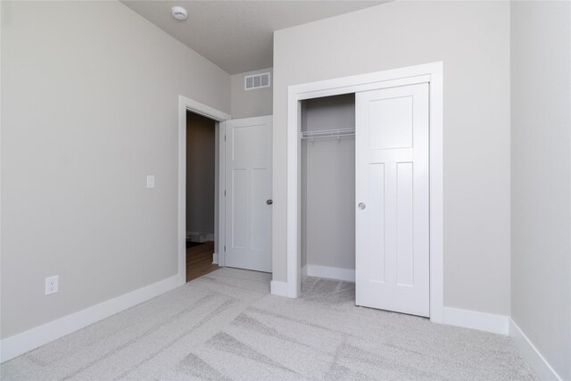 unfurnished bedroom with baseboards, visible vents, and light colored carpet