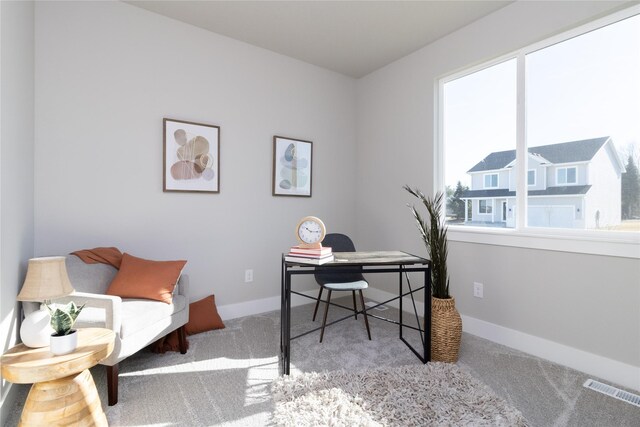 office space featuring light colored carpet, visible vents, and baseboards