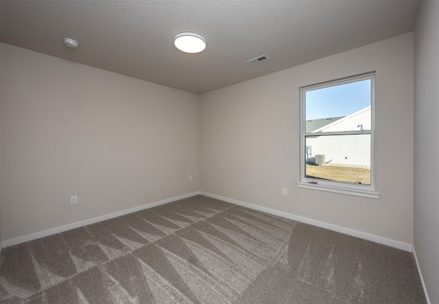 carpeted empty room featuring a textured ceiling