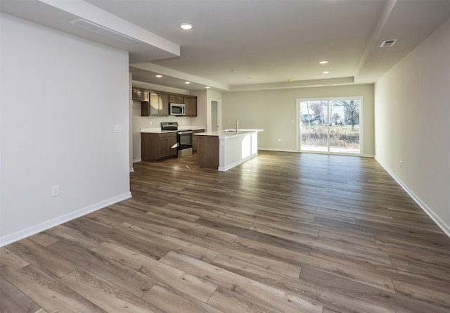 unfurnished living room with dark hardwood / wood-style flooring and sink