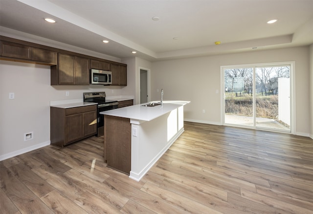 kitchen featuring light hardwood / wood-style flooring, an island with sink, stainless steel appliances, and sink