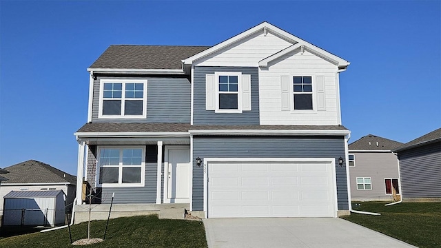 traditional-style home featuring a front lawn, concrete driveway, an attached garage, and a shingled roof