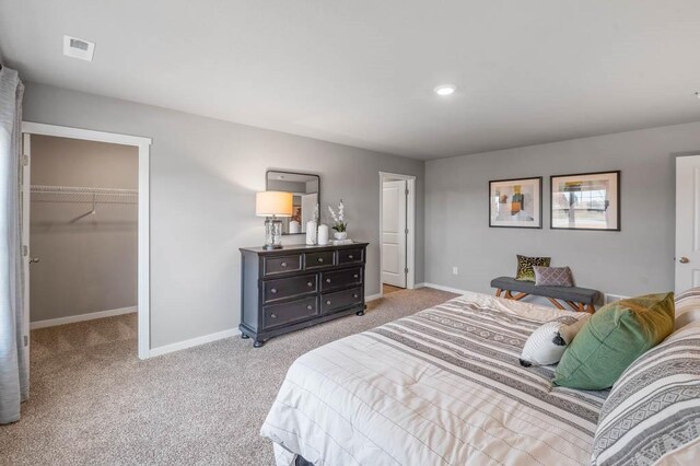 carpeted bedroom featuring visible vents, baseboards, recessed lighting, a closet, and a walk in closet
