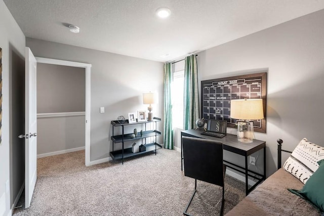 carpeted office with a textured ceiling and baseboards