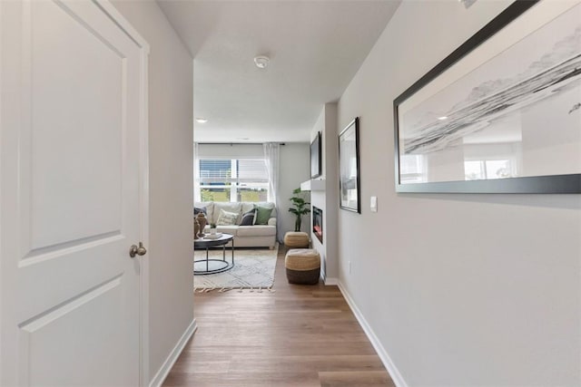 corridor featuring baseboards and wood finished floors