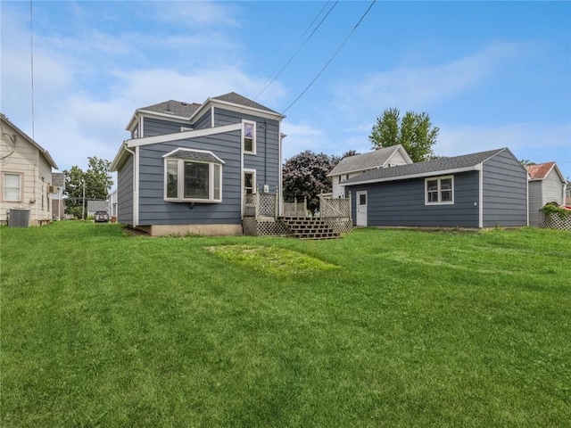 back of house featuring central air condition unit, a wooden deck, and a lawn