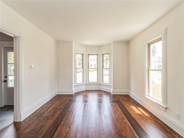 unfurnished room with dark hardwood / wood-style flooring