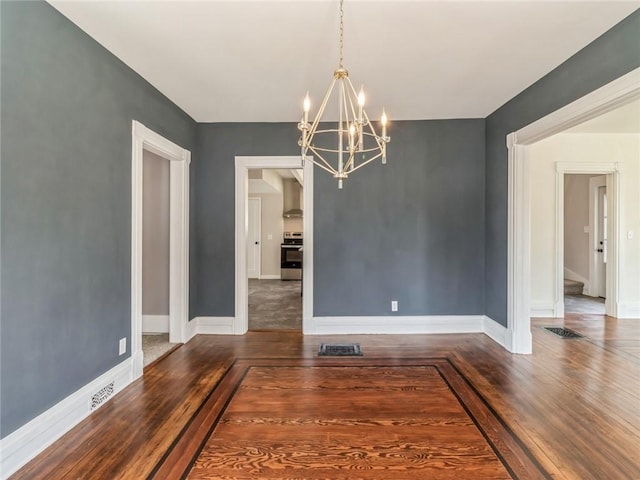 unfurnished dining area featuring dark hardwood / wood-style floors and an inviting chandelier