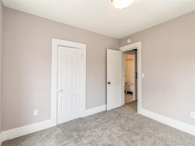 unfurnished bedroom with light carpet and a closet