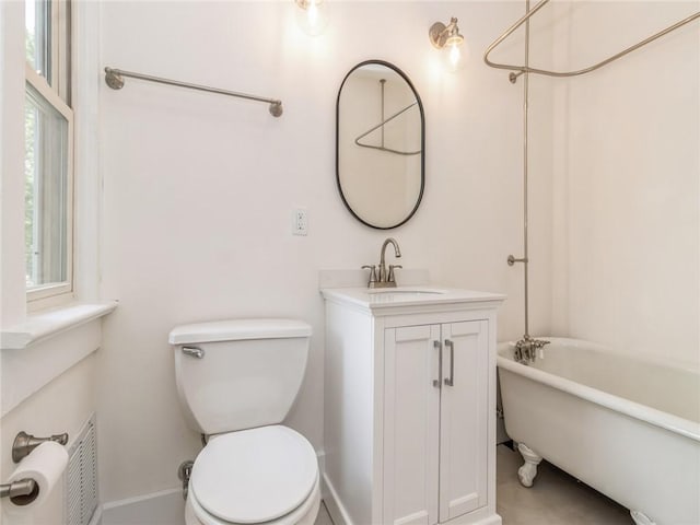 bathroom with vanity, a tub to relax in, and toilet