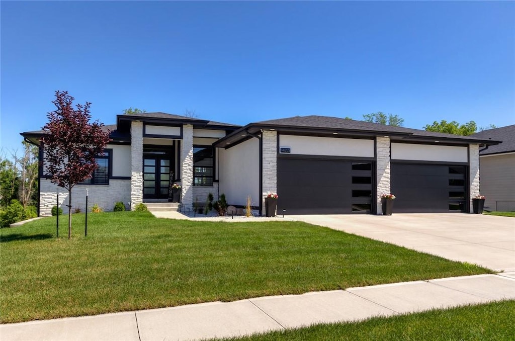 prairie-style house with a garage and a front lawn