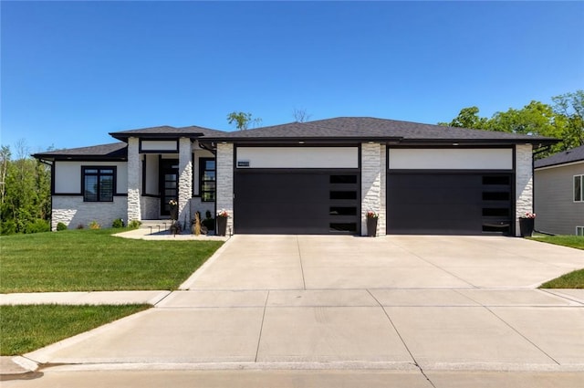 prairie-style home featuring a garage and a front lawn