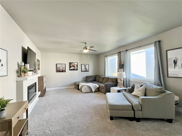 carpeted living room featuring ceiling fan and a textured ceiling