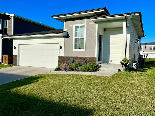 view of front of house featuring a garage, cooling unit, and a front lawn