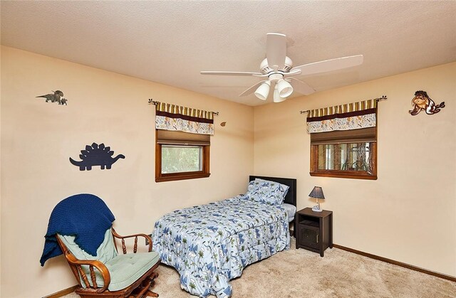 carpeted bedroom with ceiling fan and a textured ceiling