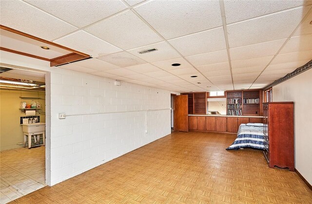 empty room featuring light parquet flooring and a paneled ceiling