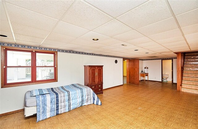 bedroom with a paneled ceiling and light parquet flooring