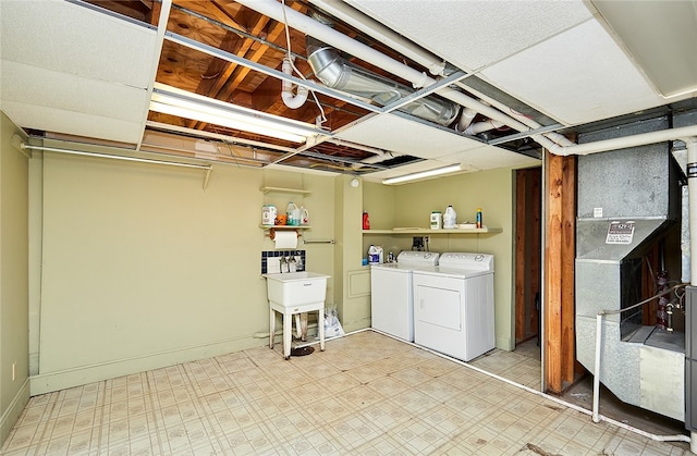 laundry room with washing machine and clothes dryer and heating unit