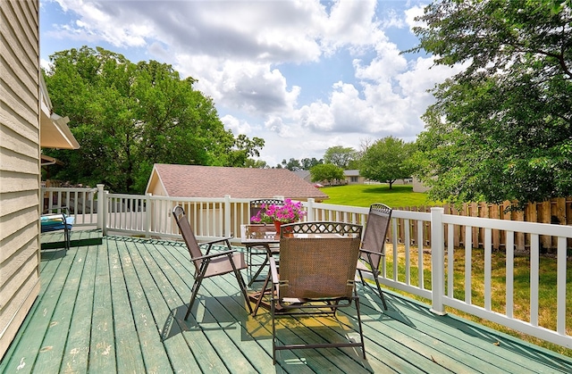 wooden deck featuring a lawn