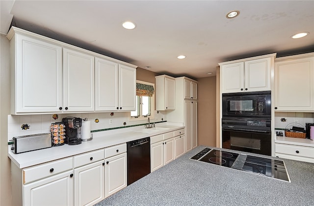 kitchen featuring black appliances, backsplash, sink, and white cabinets