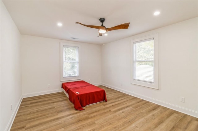 spare room with ceiling fan, light hardwood / wood-style floors, and a healthy amount of sunlight