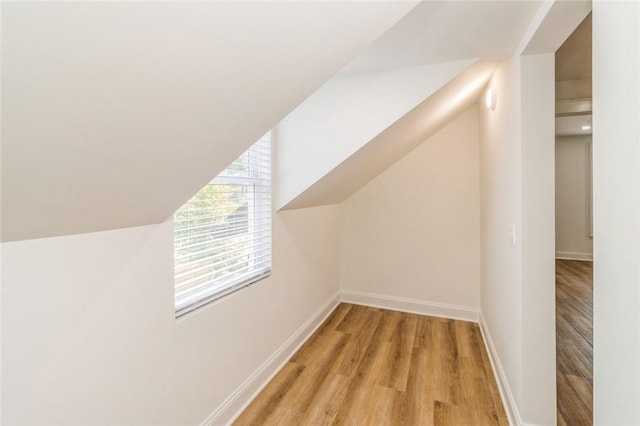 bonus room featuring vaulted ceiling and light hardwood / wood-style flooring