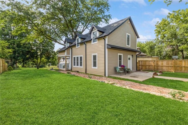 rear view of property with a yard and a patio