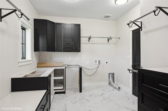 laundry room with hookup for a washing machine, light tile flooring, hookup for an electric dryer, and cabinets